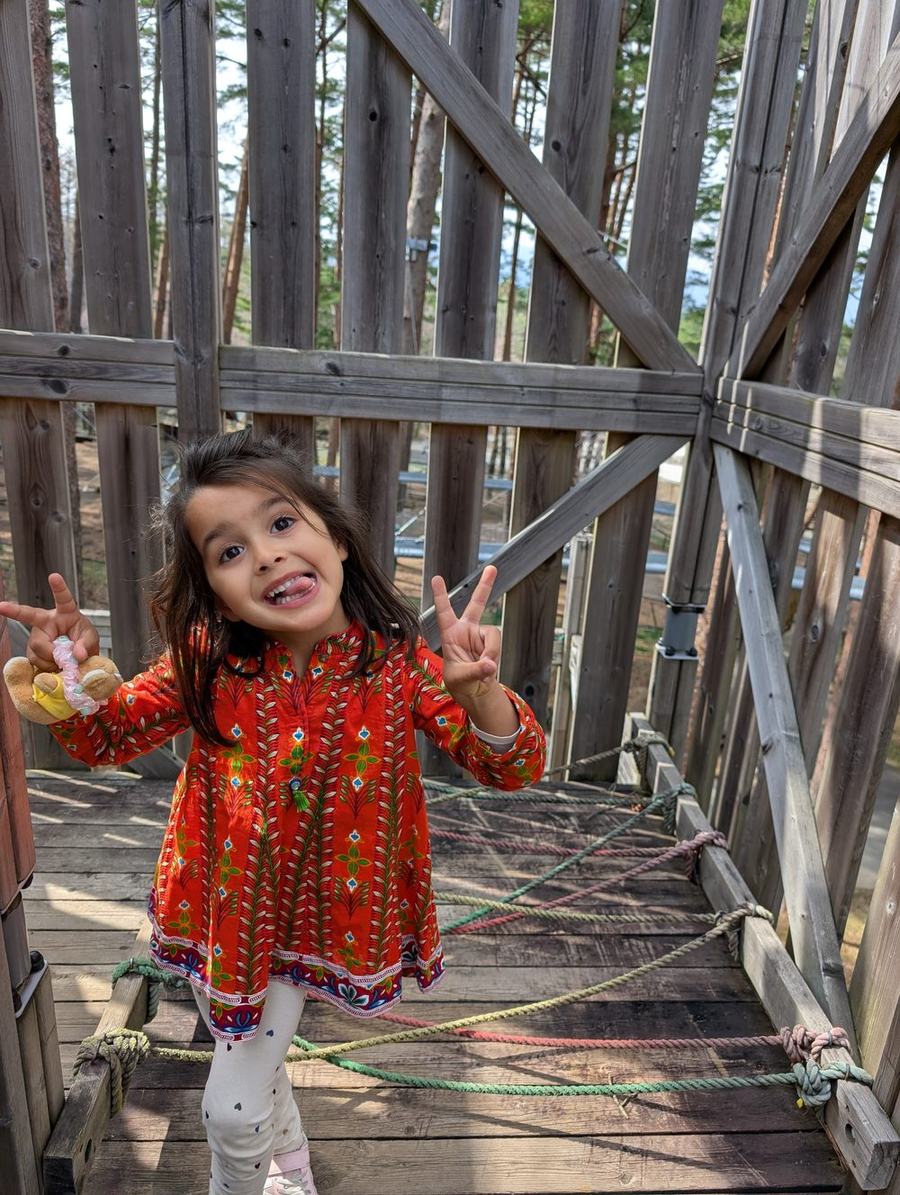A child crossing a rope-strung timber walkway inside the treehouse maze at Fuji Subaru Land